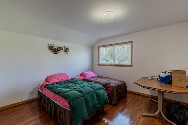 bedroom with dark wood-type flooring and vaulted ceiling