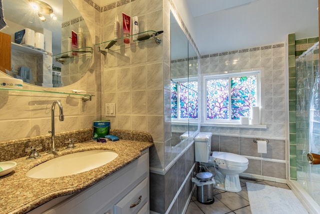 bathroom with a shower with curtain, vanity, tile walls, tile patterned flooring, and toilet