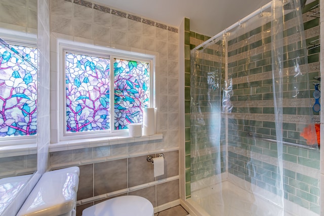 bathroom with a tile shower and tile walls