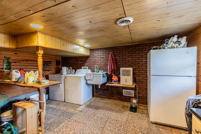 kitchen featuring wood ceiling, brick wall, separate washer and dryer, white fridge, and wood walls