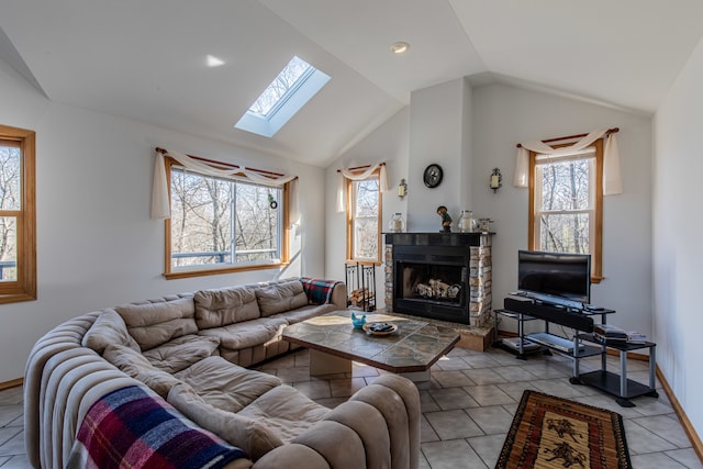 tiled living room featuring vaulted ceiling with skylight and a fireplace