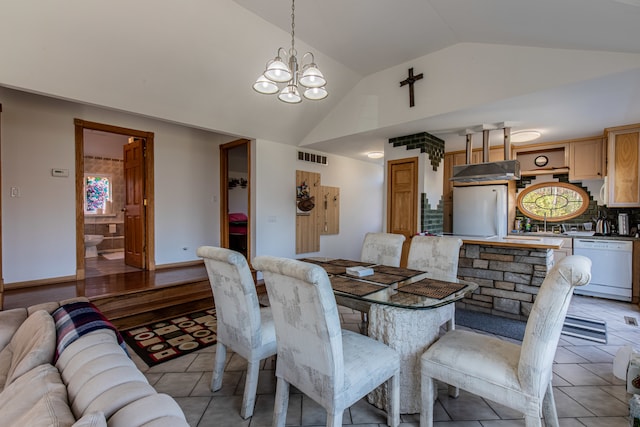 tiled dining area with a chandelier and vaulted ceiling