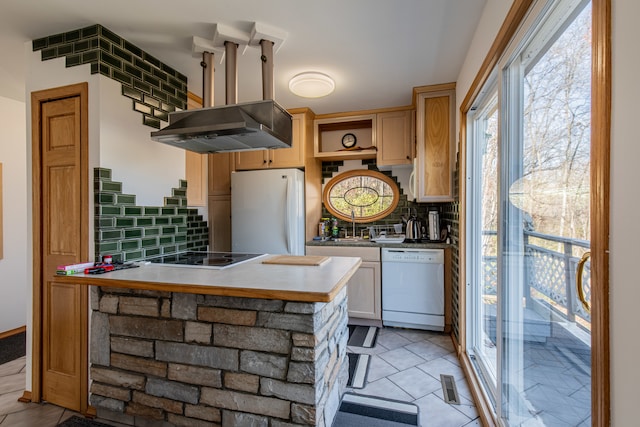 kitchen with tasteful backsplash, light brown cabinetry, exhaust hood, and white appliances