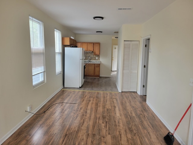 kitchen featuring white refrigerator, dark hardwood / wood-style flooring, a healthy amount of sunlight, and sink