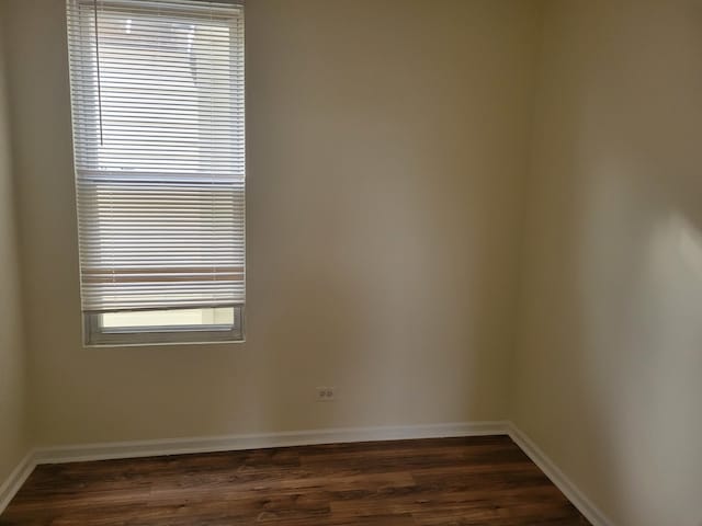 unfurnished room with dark wood-type flooring