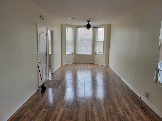 spare room with dark hardwood / wood-style flooring and ceiling fan