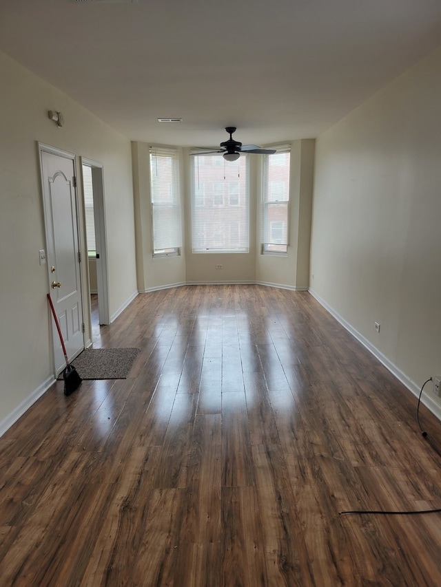 spare room with ceiling fan and dark wood-type flooring