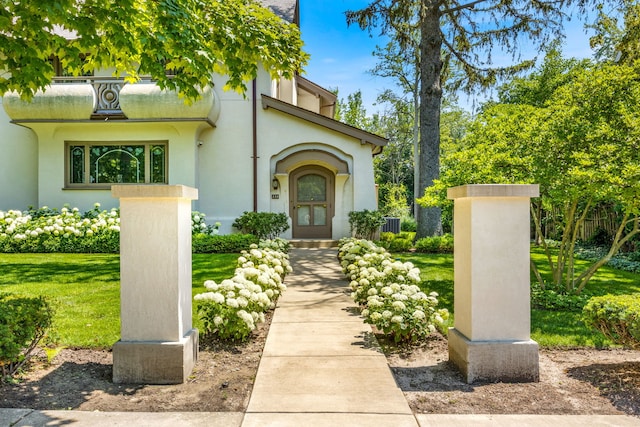 property entrance featuring a lawn