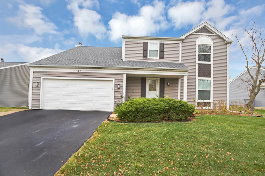 front facade with a garage and a front lawn