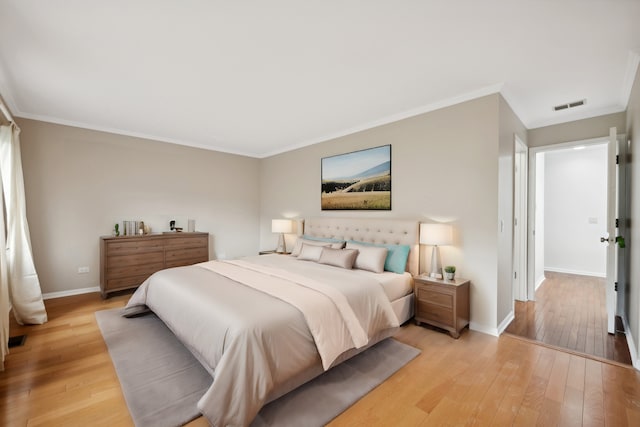 bedroom featuring crown molding and light hardwood / wood-style flooring