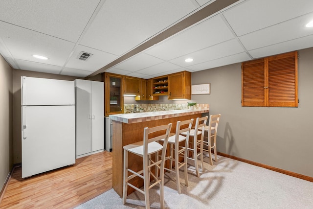 1310 Yorkshire Woods Ct, Wheaton, IL 60189 - kitchen with freestanding refrigerator, brown cabinetry, open shelves, light countertops, and a peninsula