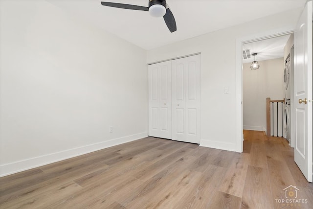 unfurnished bedroom featuring a closet, light hardwood / wood-style floors, and ceiling fan