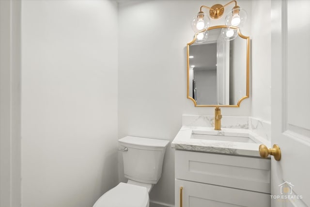 bathroom featuring an inviting chandelier, vanity, and toilet