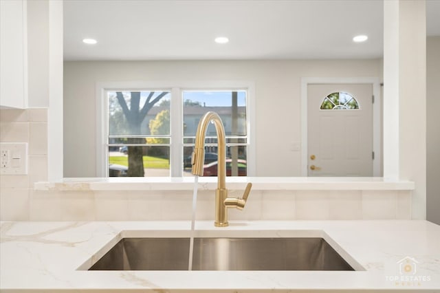 kitchen with light stone countertops and sink