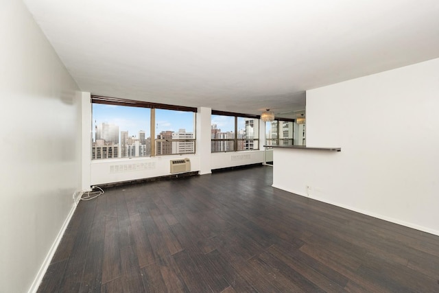 unfurnished living room with a wall mounted AC and dark hardwood / wood-style floors