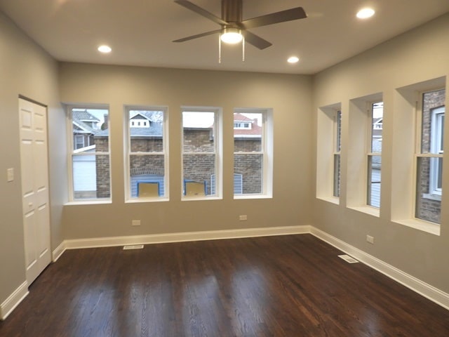 empty room featuring ceiling fan and dark wood-type flooring