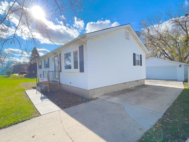 view of side of home with a garage, an outdoor structure, and a lawn