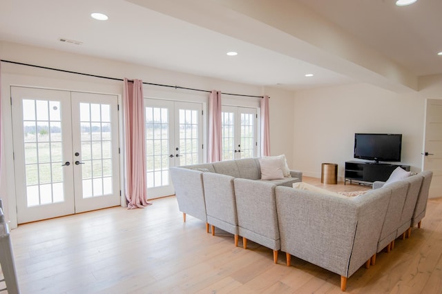 living room featuring french doors, a healthy amount of sunlight, and light wood-type flooring