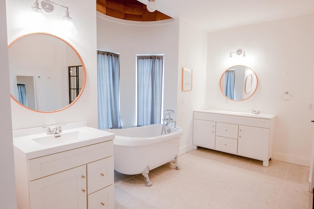 bathroom with a towering ceiling, vanity, tile patterned floors, and a tub