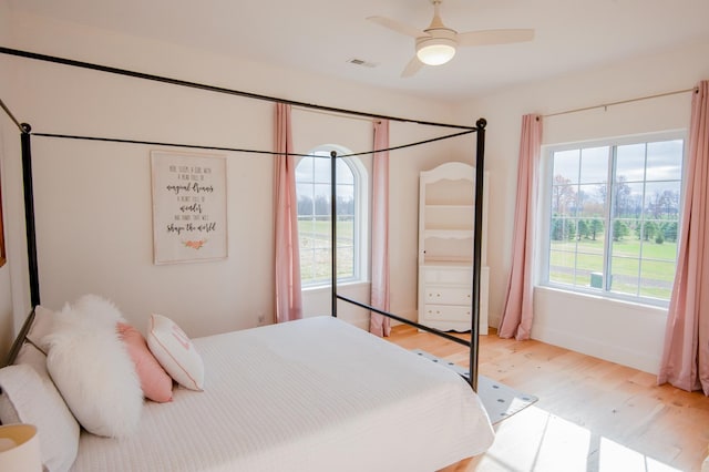 bedroom with multiple windows, ceiling fan, and light hardwood / wood-style flooring