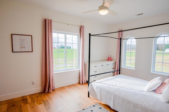 bedroom with light hardwood / wood-style flooring, multiple windows, and ceiling fan