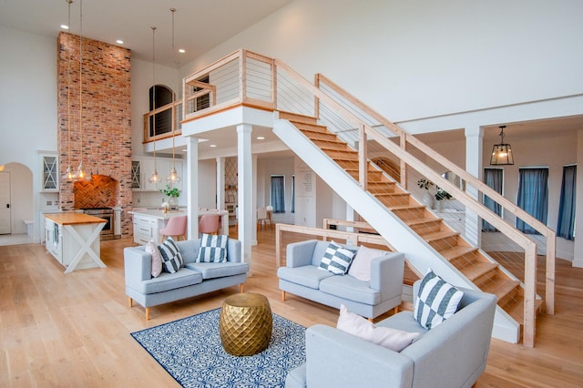 living room featuring light hardwood / wood-style flooring and a towering ceiling