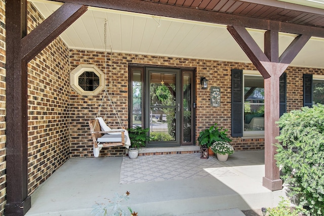 view of exterior entry featuring covered porch