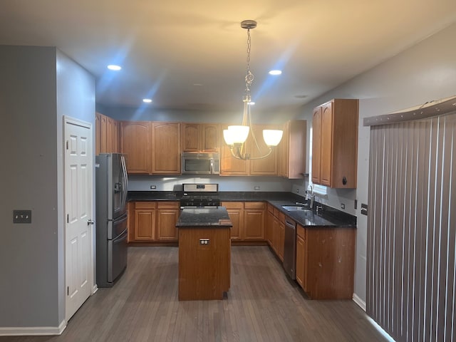 kitchen with stainless steel appliances, a chandelier, a kitchen island, dark wood finished floors, and recessed lighting