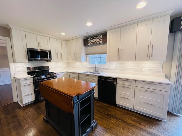 kitchen featuring appliances with stainless steel finishes, backsplash, dark wood-type flooring, sink, and white cabinets