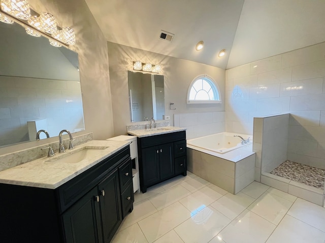 bathroom with tile patterned floors, tiled bath, vanity, and lofted ceiling