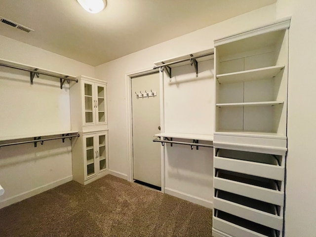 spacious closet with dark carpet