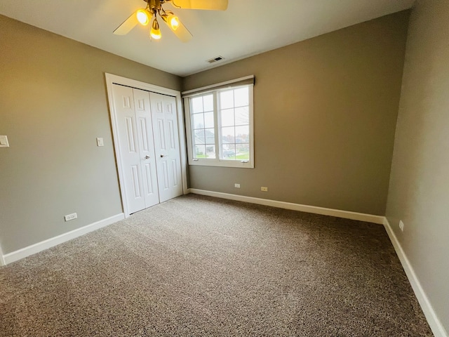 unfurnished bedroom featuring ceiling fan, a closet, and carpet