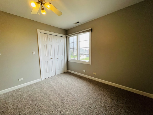 unfurnished bedroom with ceiling fan, a closet, and carpet floors