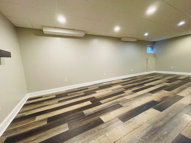 basement with hardwood / wood-style flooring and a drop ceiling