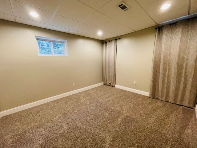 basement with a drop ceiling and carpet floors