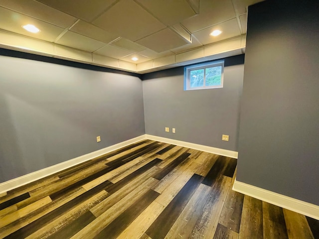 unfurnished room with a paneled ceiling and dark hardwood / wood-style flooring