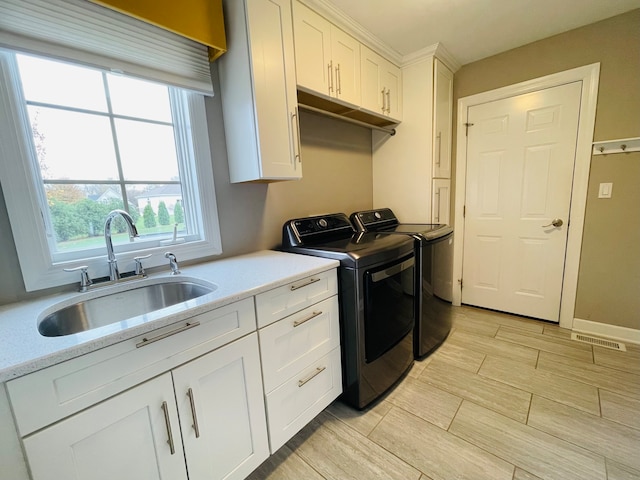 laundry room featuring sink, cabinets, and independent washer and dryer