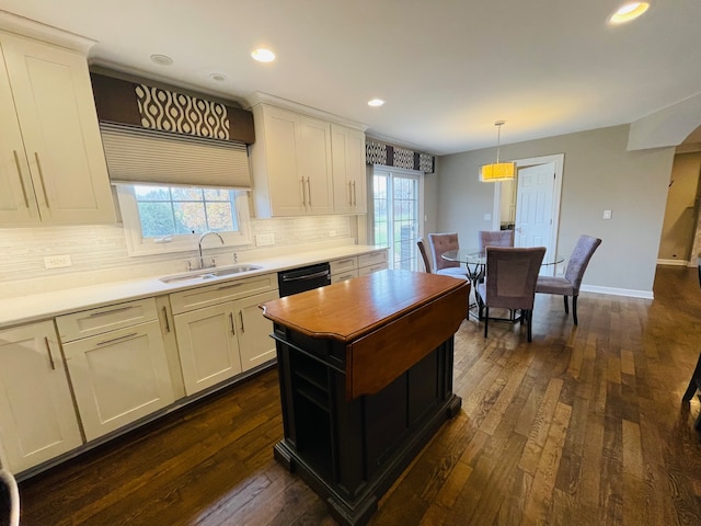 kitchen with dishwasher, sink, hanging light fixtures, dark wood-type flooring, and white cabinets