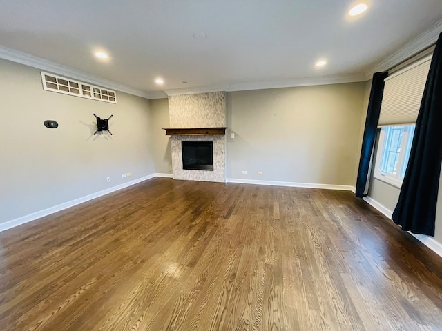 unfurnished living room featuring a large fireplace, hardwood / wood-style flooring, and ornamental molding