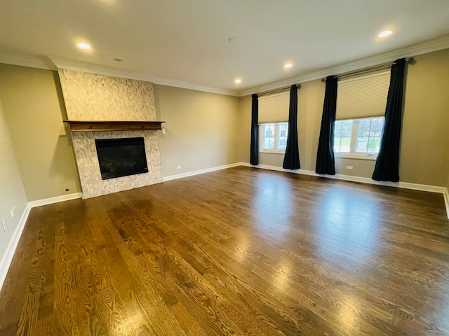 unfurnished living room featuring hardwood / wood-style floors, ornamental molding, and a fireplace