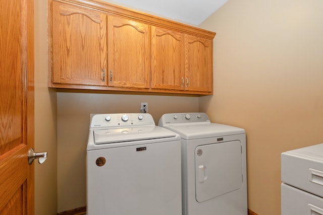 washroom featuring cabinets and independent washer and dryer