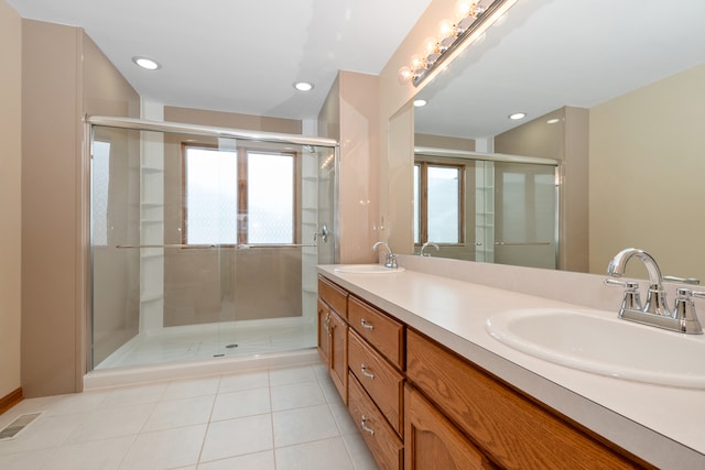 bathroom with tile patterned floors, a wealth of natural light, vanity, and walk in shower