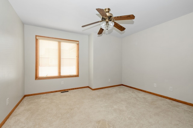 spare room featuring ceiling fan and light carpet