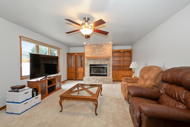 carpeted living room with a fireplace and ceiling fan