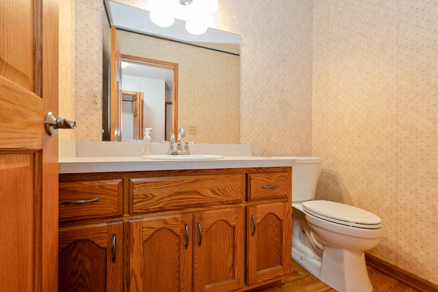 bathroom with vanity, toilet, and wood-type flooring