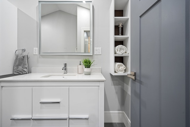 bathroom with vanity and lofted ceiling