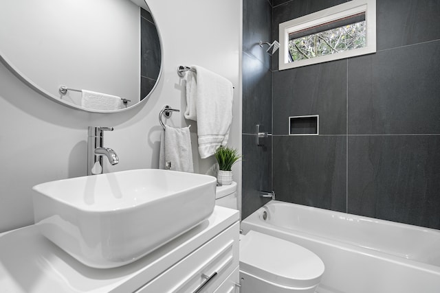 full bathroom with vanity, toilet, and tiled shower / bath