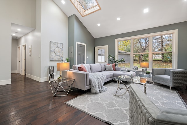 living room featuring dark hardwood / wood-style flooring, high vaulted ceiling, and a skylight