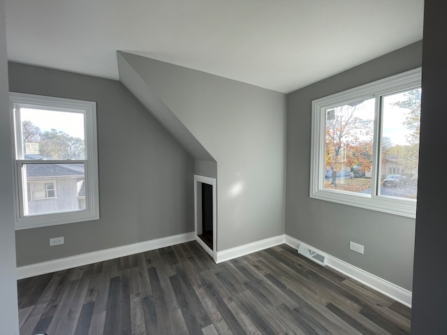 additional living space with dark hardwood / wood-style flooring and a healthy amount of sunlight