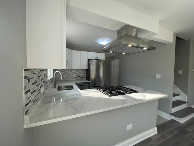 kitchen with island exhaust hood, kitchen peninsula, stainless steel appliances, sink, and white cabinets